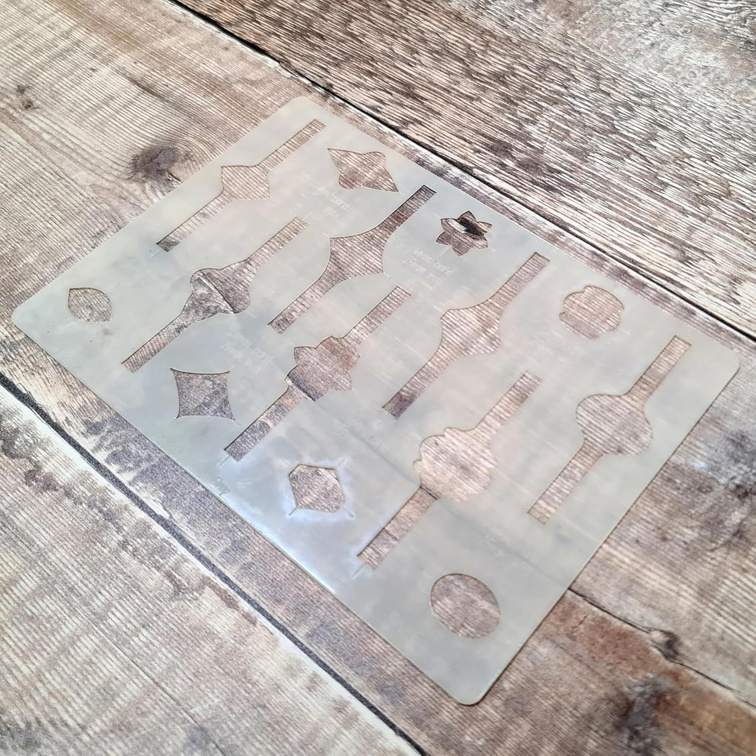 Metal stencil with geometric shapes on a wooden surface