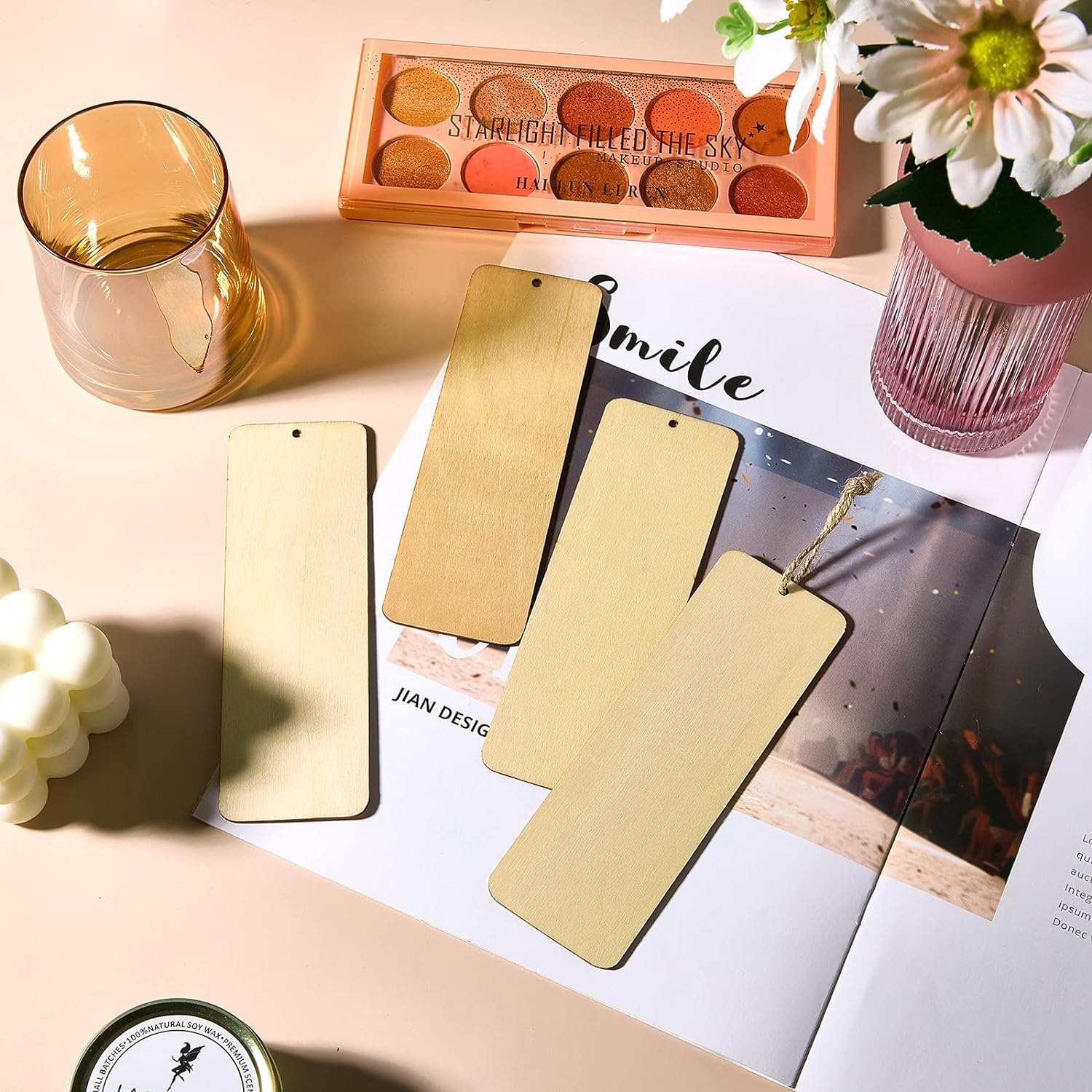Gold phone cases on a magazine with a glass of juice and flowers in the background