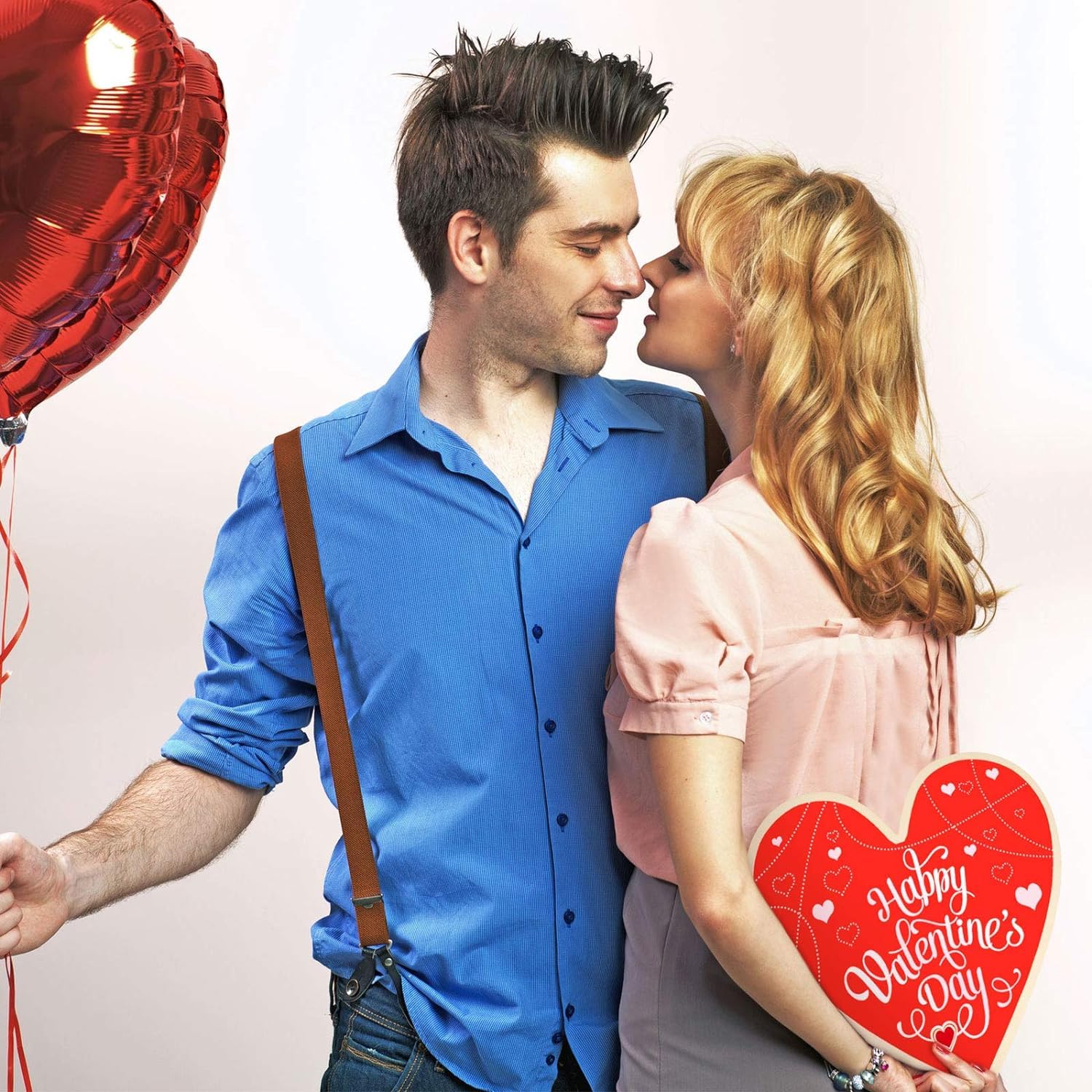 Couple celebrating Valentine's Day with a heart-shaped balloon and card.