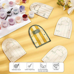 Wooden fairy doors with paint supplies on a yellow surface
