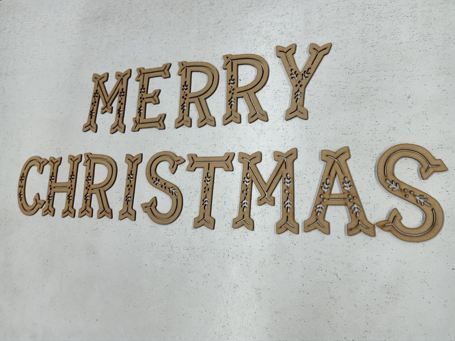 Wooden 'Merry Christmas' decoration on a light background