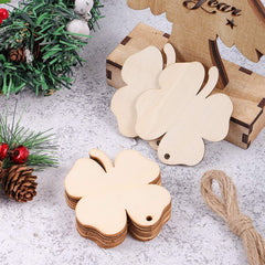 Wooden four-leaf clover tags on a textured surface with Christmas decorations.