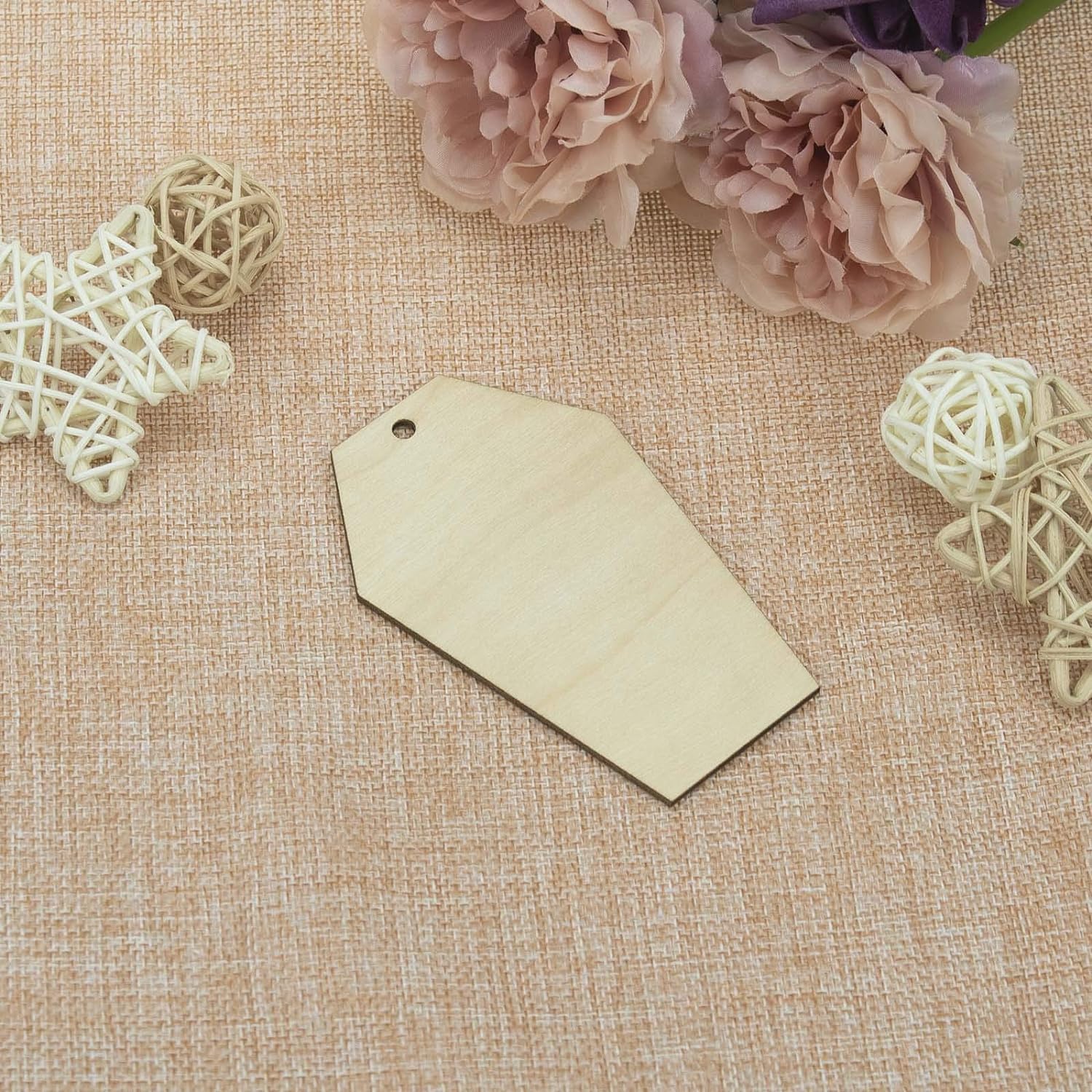 Blank beige tag on a textured fabric background with decorative elements
