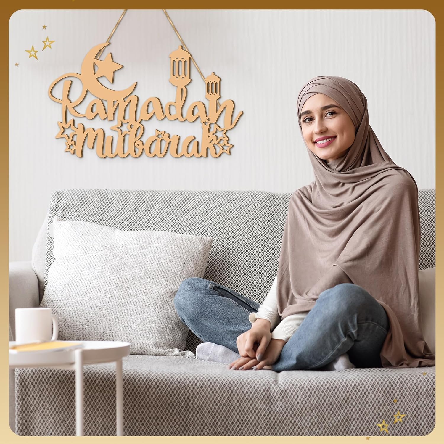 Woman sitting on a couch with 'Ramadhan Mubarak' decoration above her