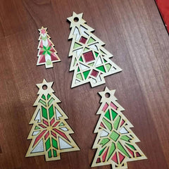 Four geometric Christmas tree ornaments on a wooden surface
