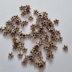 Bronze star-shaped objects scattered on a light gray background