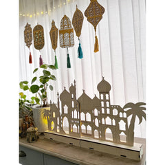 Decorative screen with architectural silhouette and hanging lanterns on a white curtain background