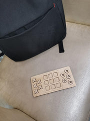 Wooden puzzle on a beige surface with a black backpack in the background