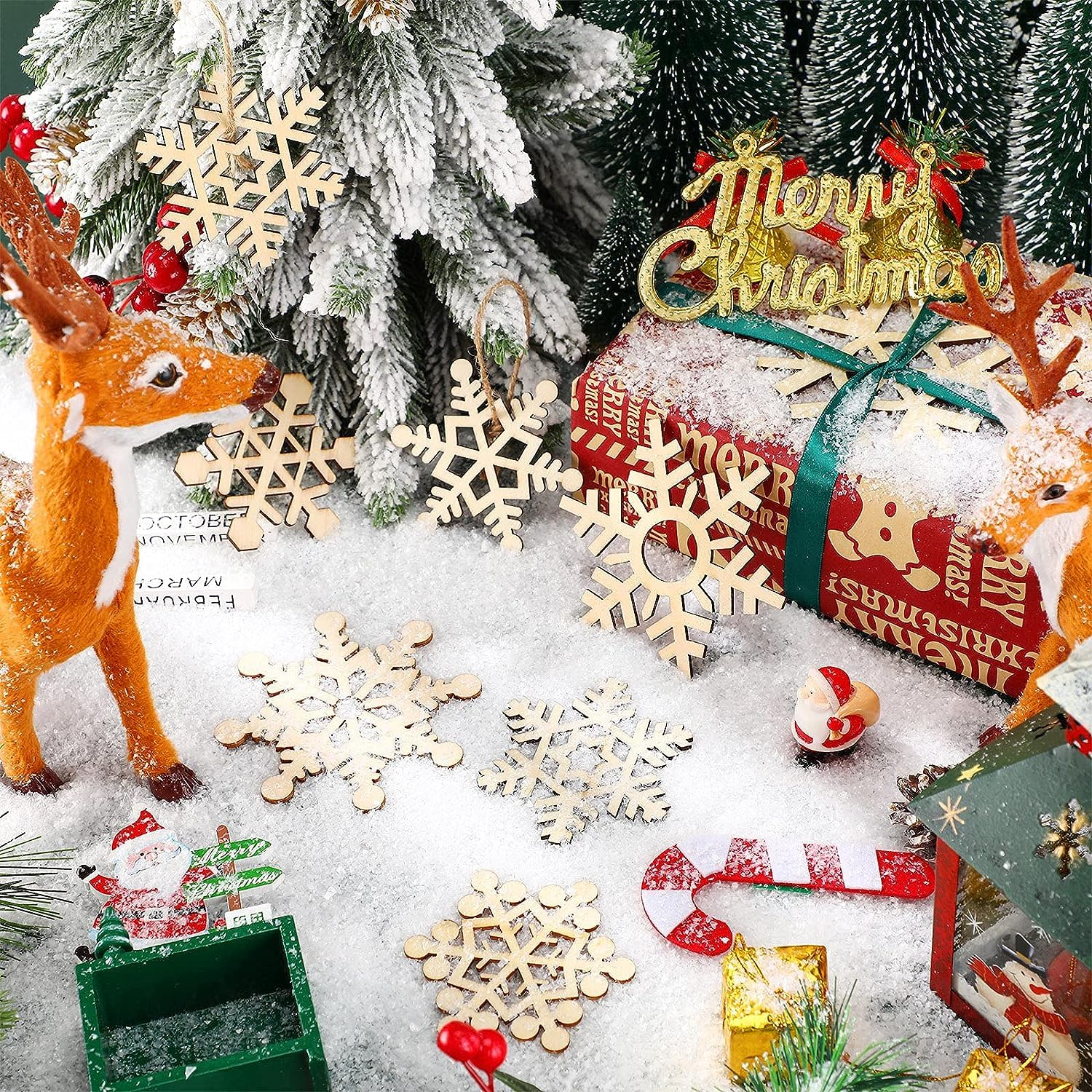Christmas-themed decorations including a deer, snowflakes, and wrapped gifts on a snowy surface.