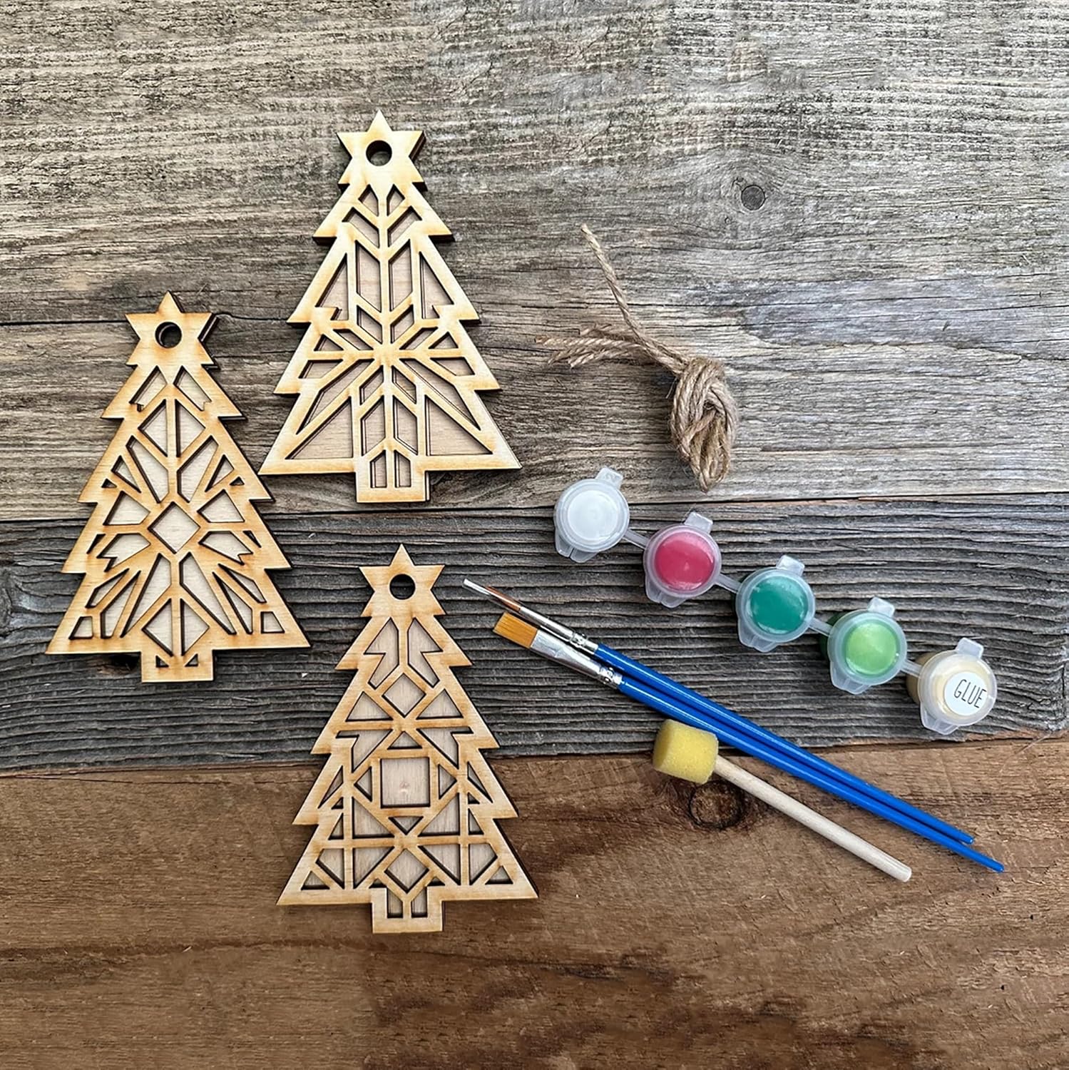 Wooden Christmas tree ornaments with paint and brushes on a wooden surface