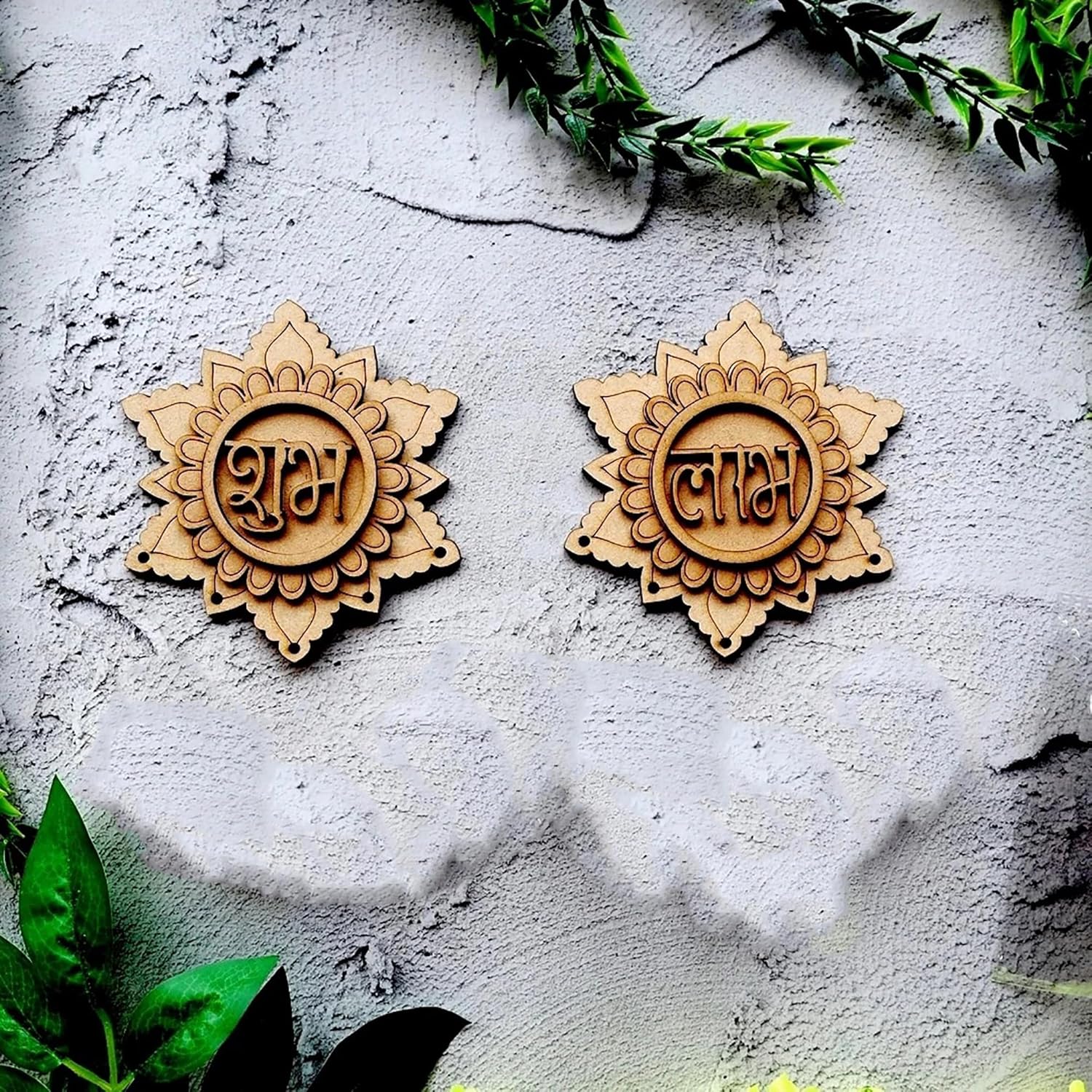 Two wooden decorative items with engraved designs on a textured surface with green leaves.