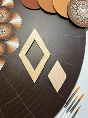 Wooden diamond shapes on a dark surface with paintbrushes and decorative items.
