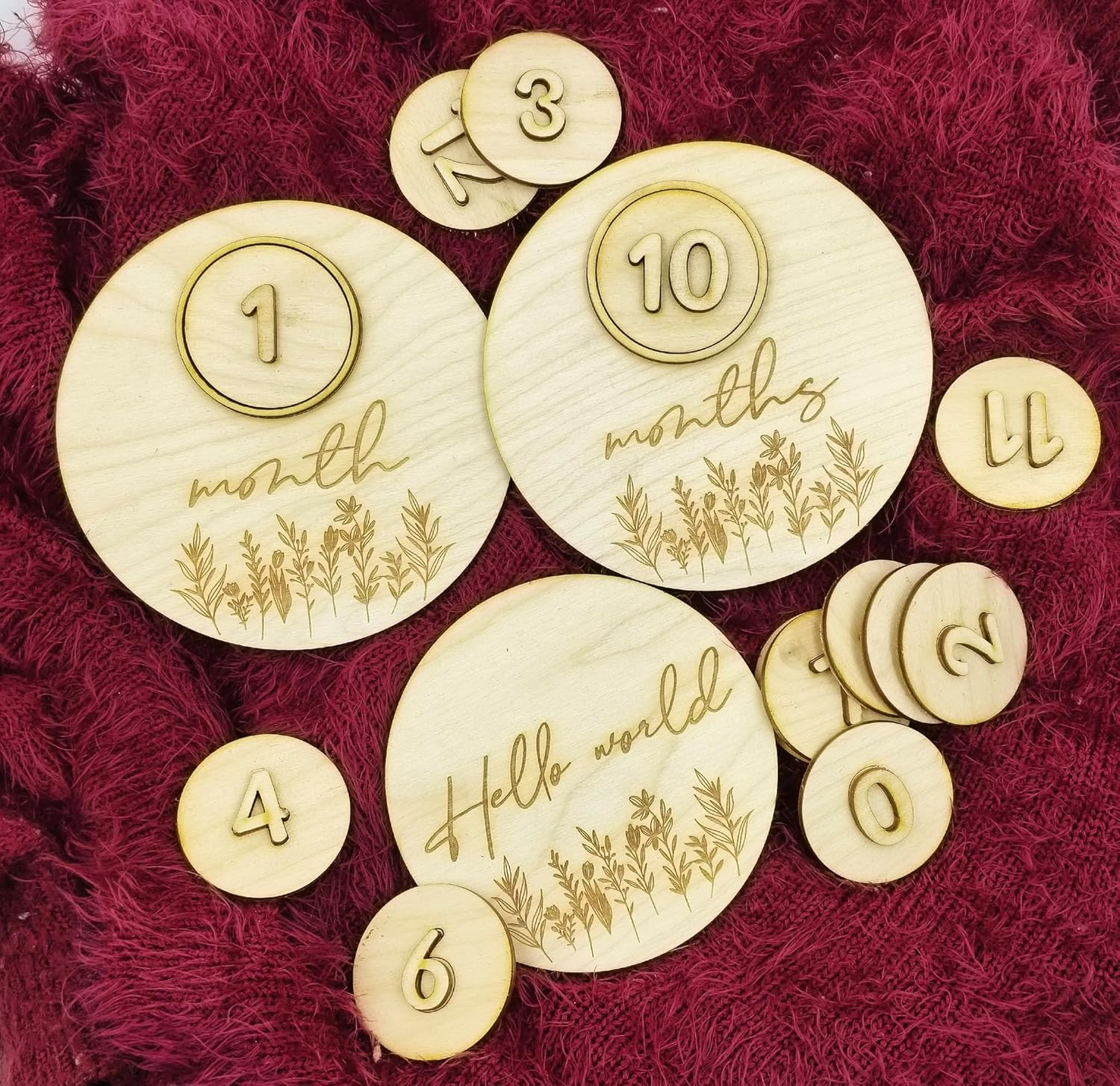 Wooden milestone discs with numbers and text on a red textured background