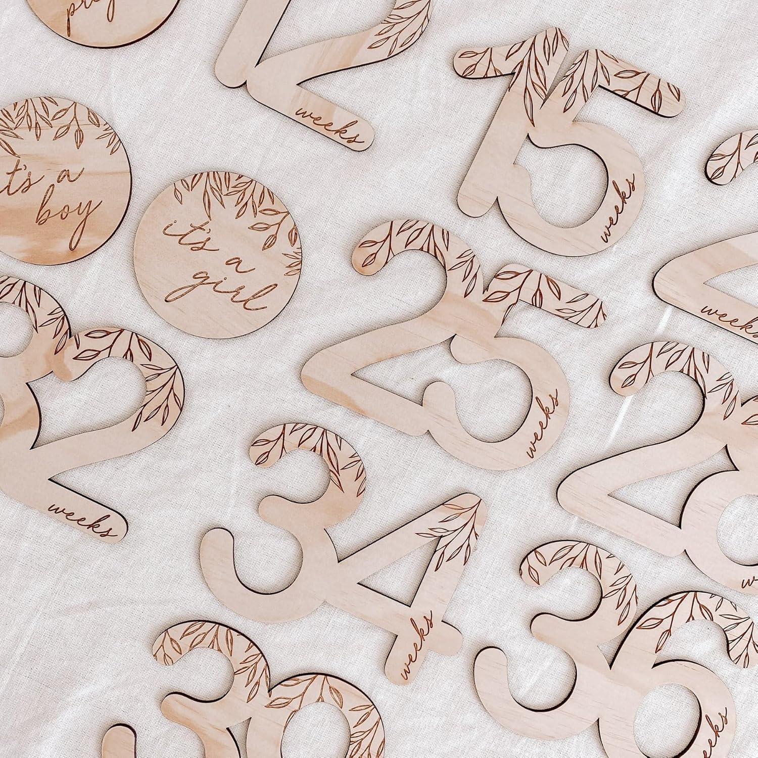 Wooden baby milestone markers with numbers and 'it's a boy'/'it's a girl' text on a white background.