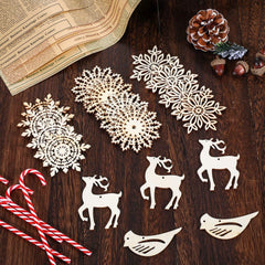 Decorative cutout shapes of snowflakes, reindeer, and birds on a wooden surface with a newspaper and pinecones.