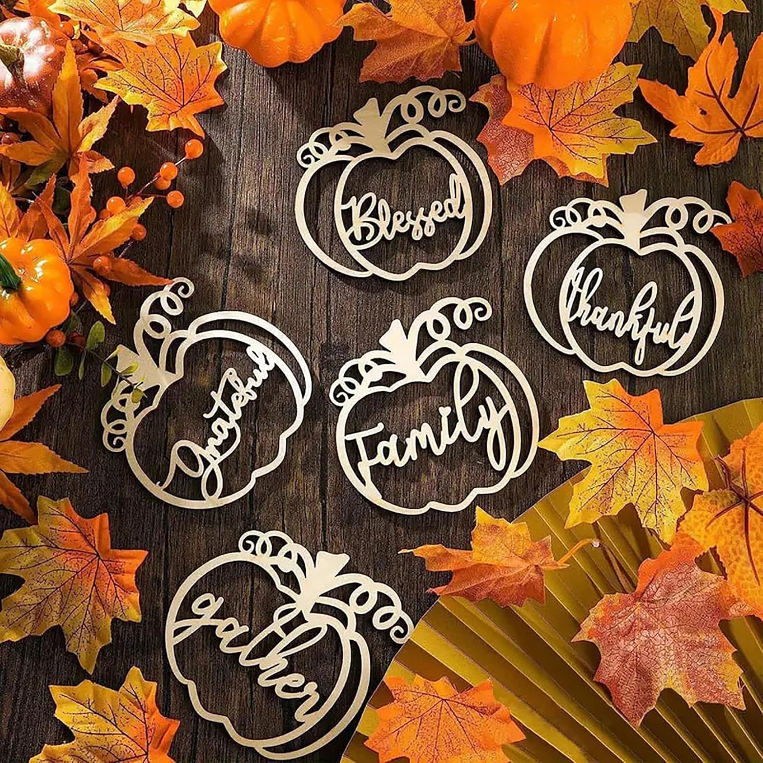 Decorative pumpkin-shaped cutouts with autumn leaves on a wooden surface