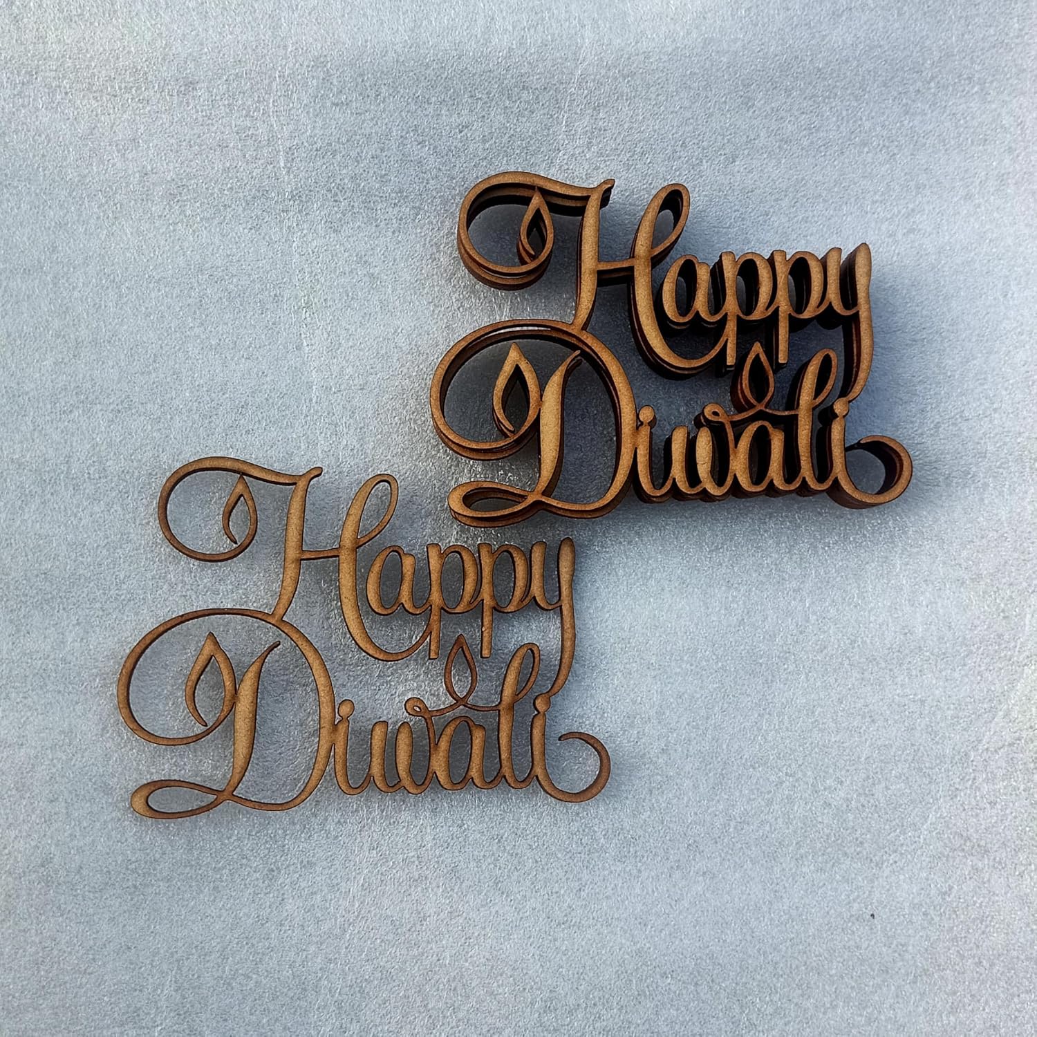 Wooden 'Happy Diwali' decoration on a light gray background