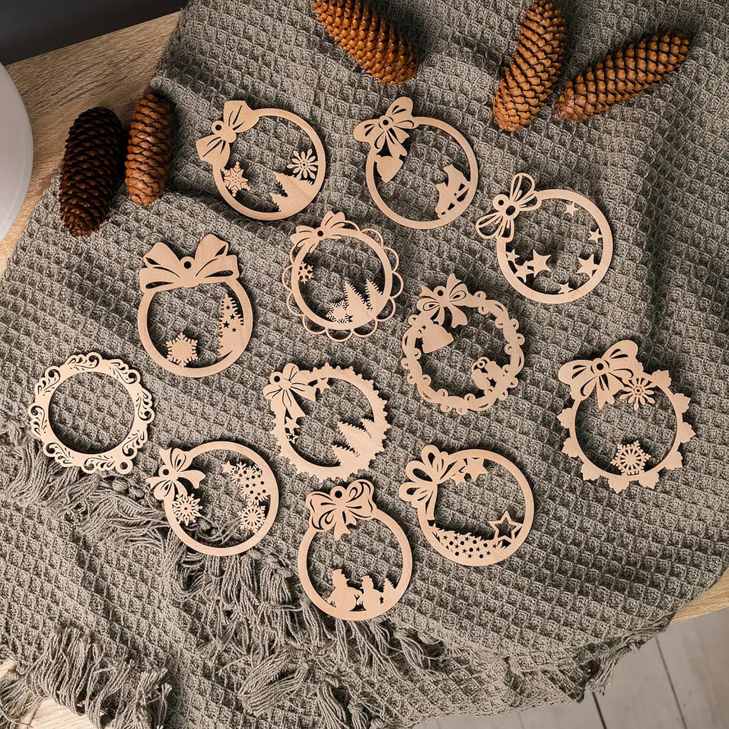 Decorative wooden ornaments on a textured fabric surface with pine cones.