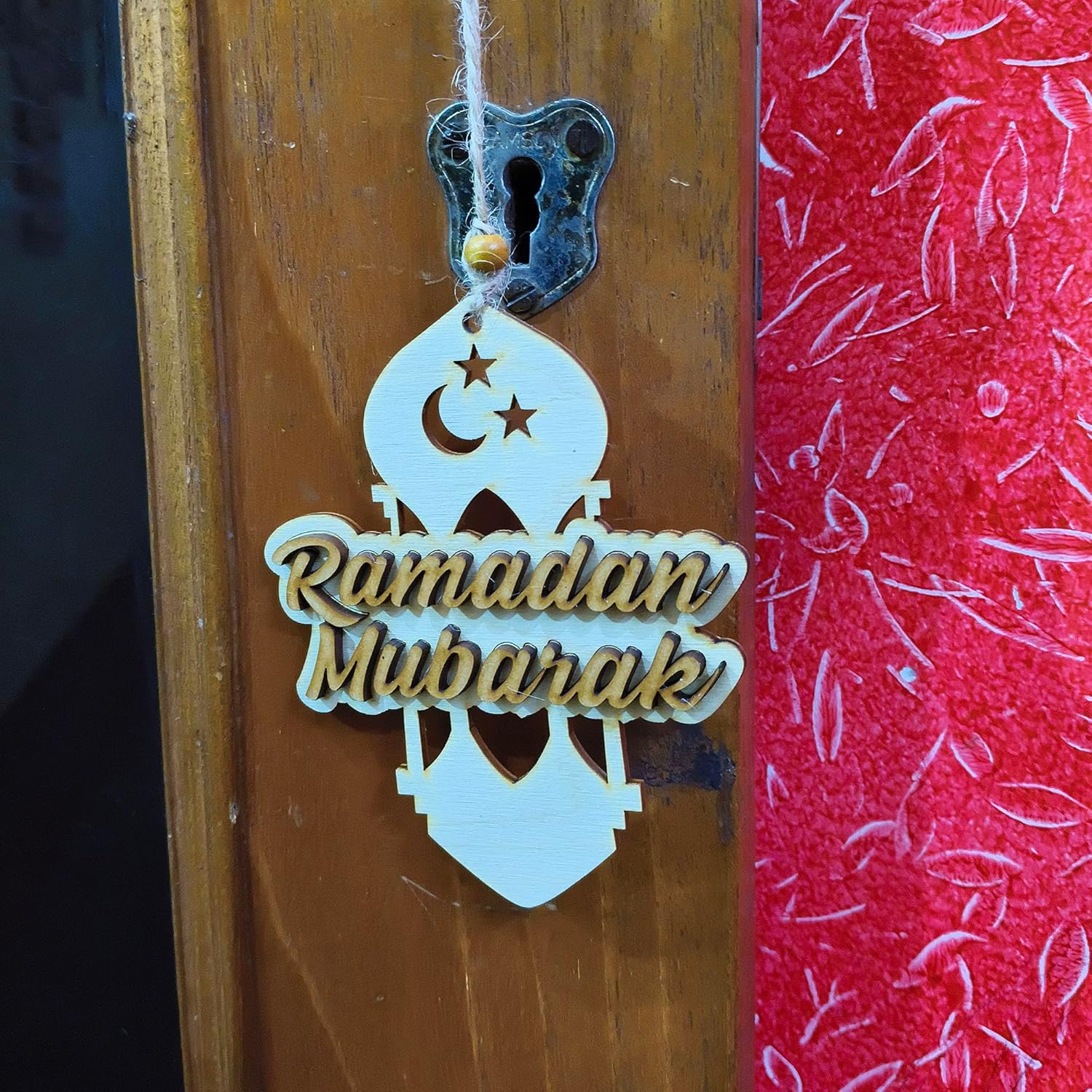 Decorative hanging sign with 'Ramadan Mubarak' on a wooden door.