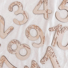 Wooden numbers with 'month' text on a textured surface