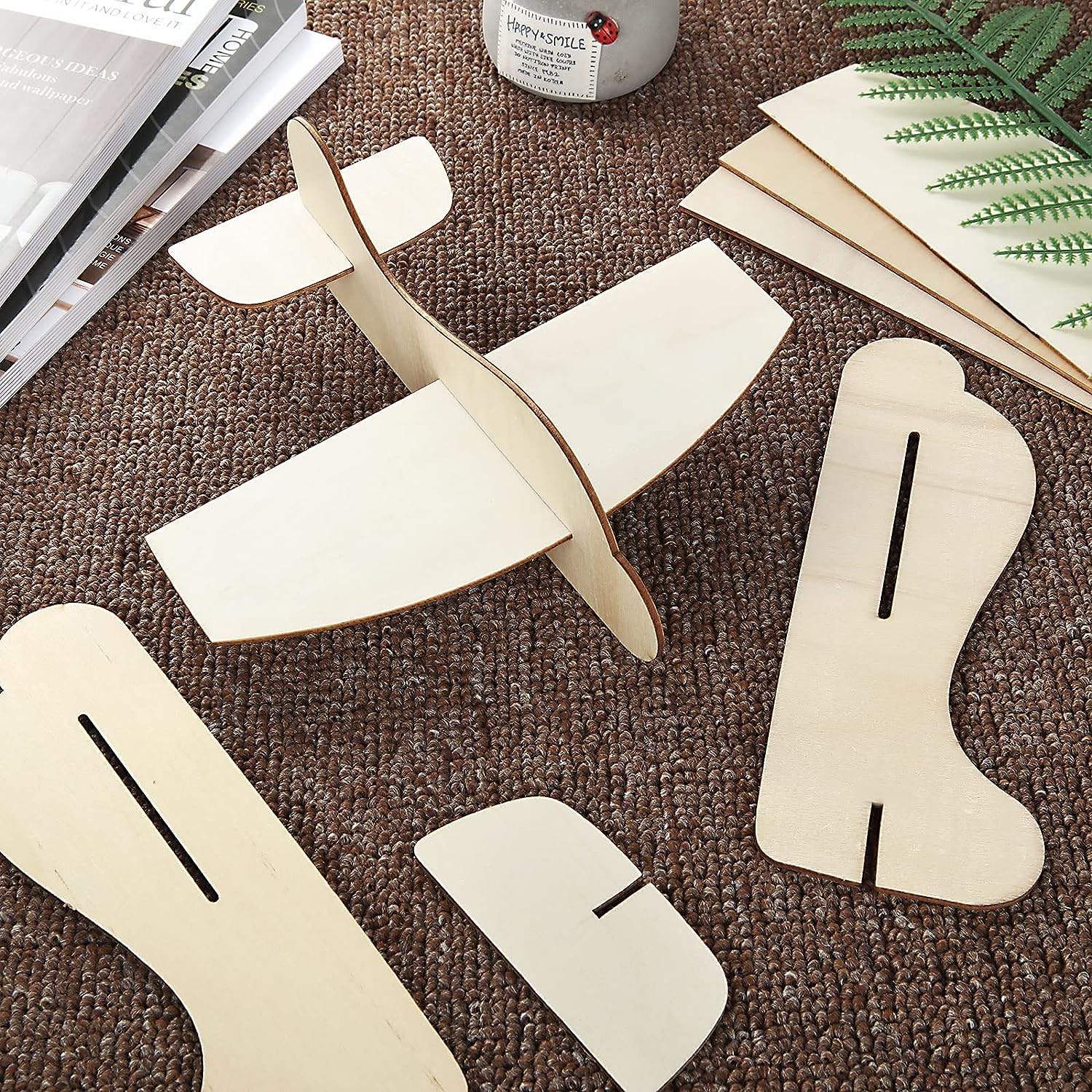 Wooden airplane models on a textured surface with books and a plant in the background.