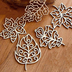 Decorative wooden leaf cutouts on a wooden surface