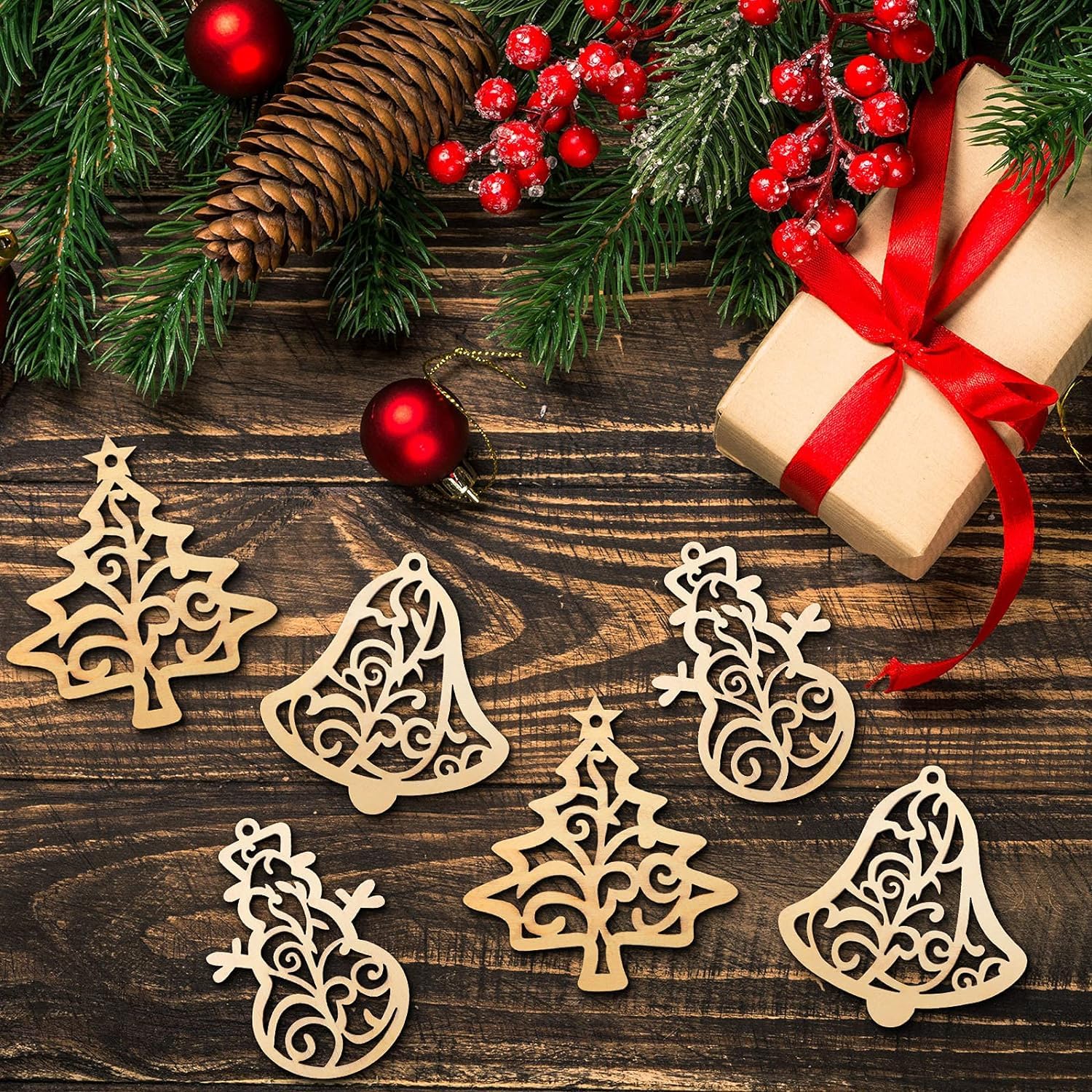 Wooden Christmas ornaments on a wooden surface with a gift and decorations.