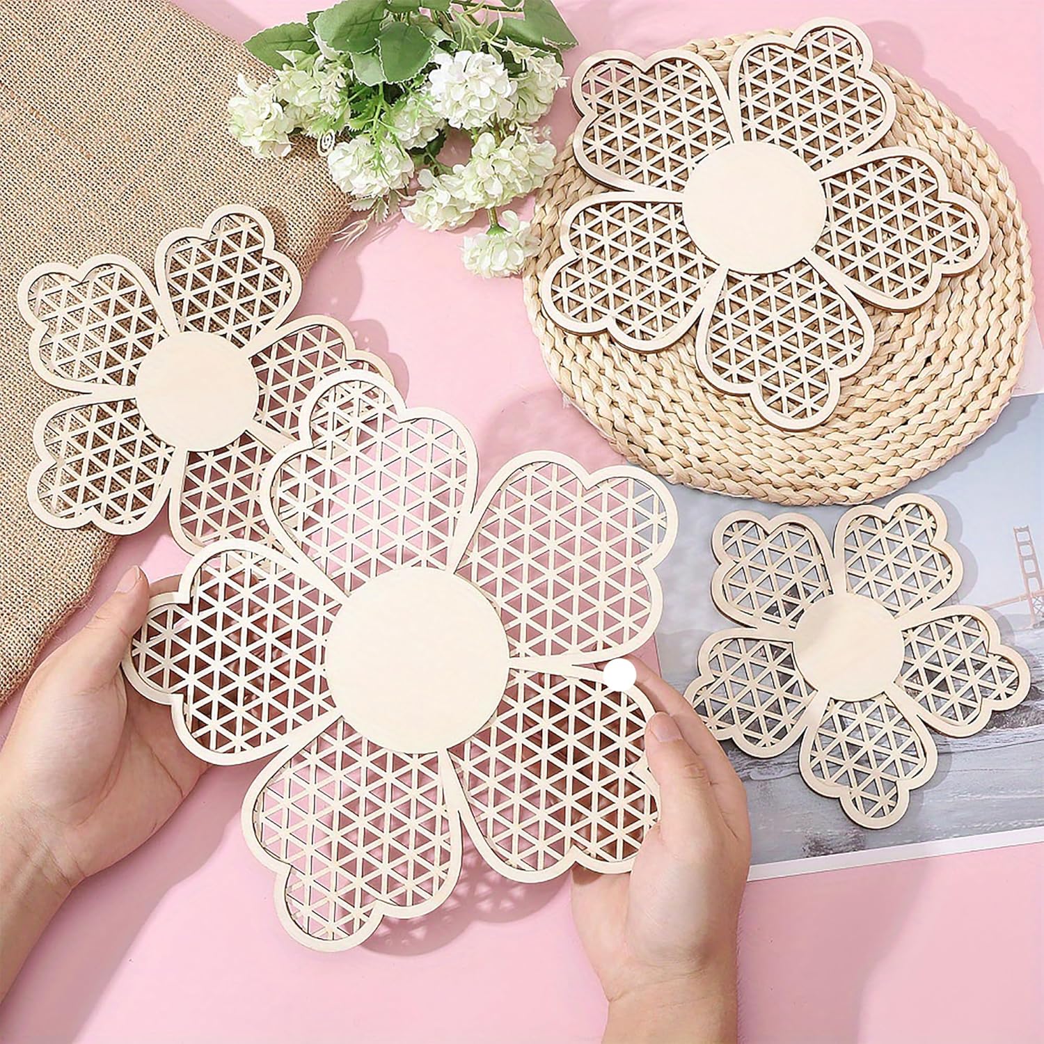 Floral-patterned coasters on a pink surface with a hand holding one coaster.