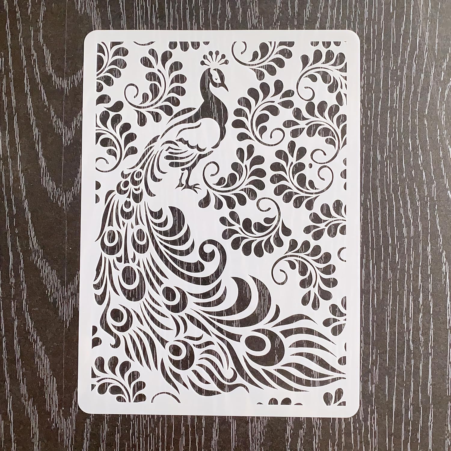 Decorative stencil with peacock design on a wooden surface