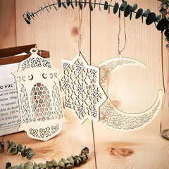 Decorative metal hanging ornaments on a wooden surface with eucalyptus leaves.