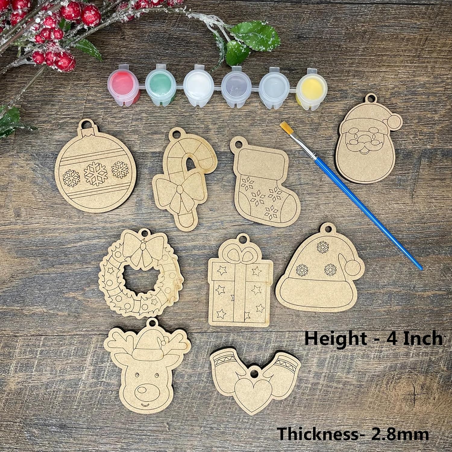 Wooden Christmas ornaments with paint samples and a brush on a wooden surface
