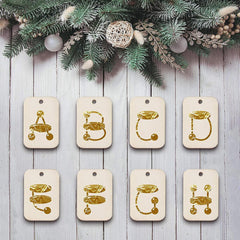 Set of gold letter tags on a wooden surface with Christmas decorations above