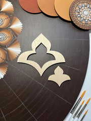 Decorative wooden cutout on a dark surface with color swatches and tools.