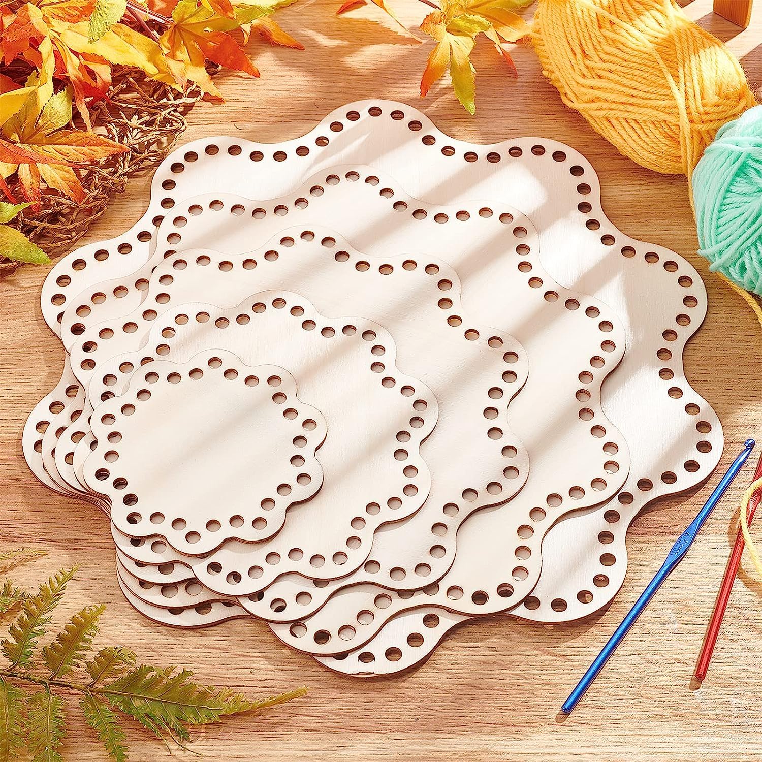 Wooden lace-making board with yarn and crochet hooks on a wooden surface.