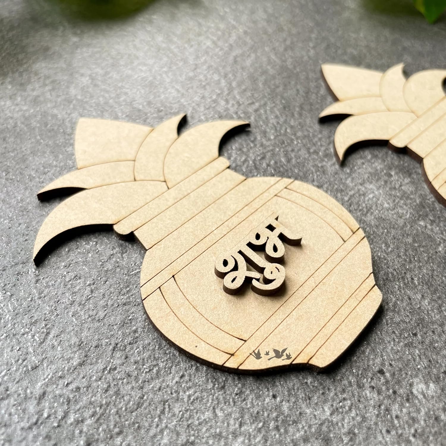 Wooden pineapple-shaped decorative item with engraved text on a gray surface