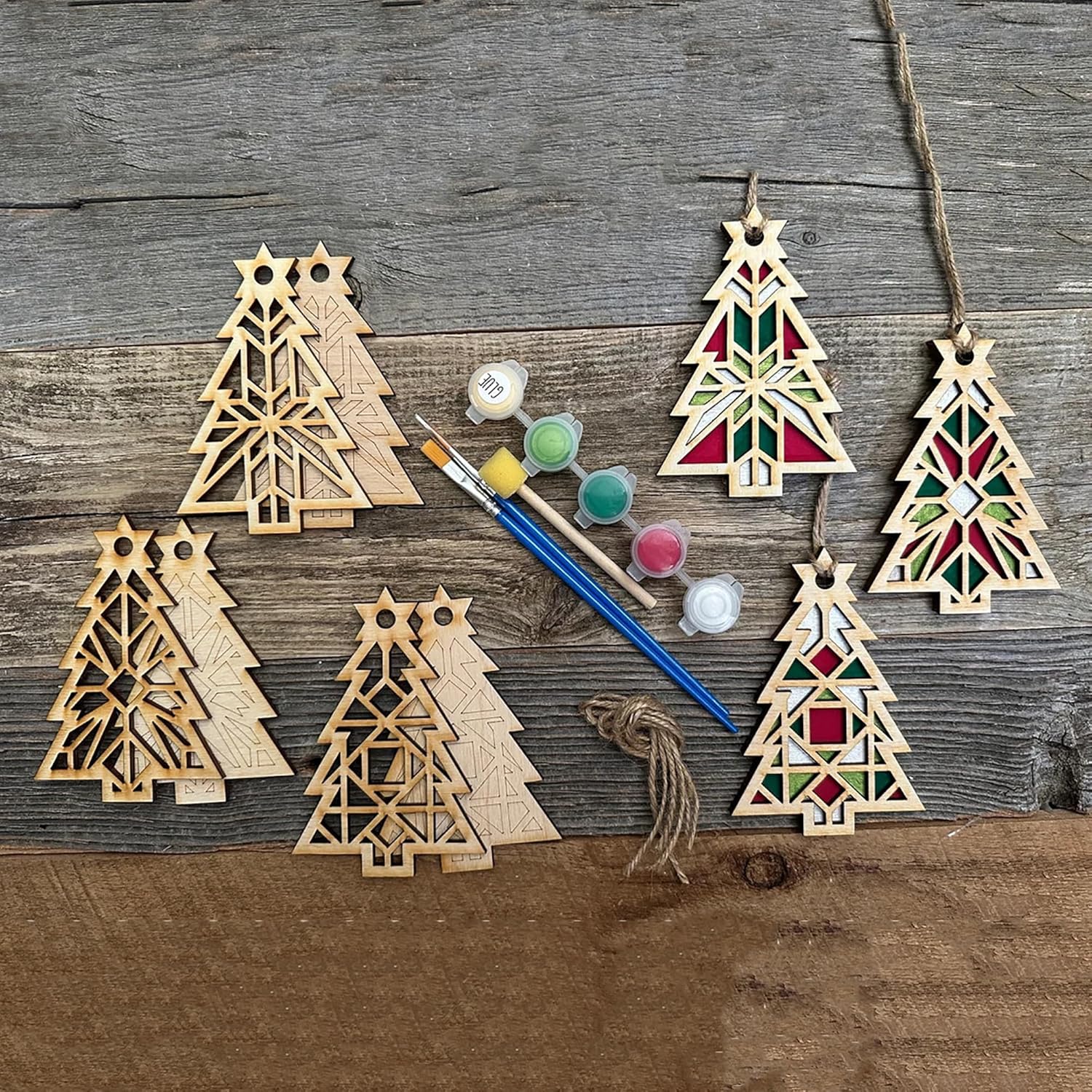 Wooden Christmas tree ornaments with paint supplies on a wooden surface