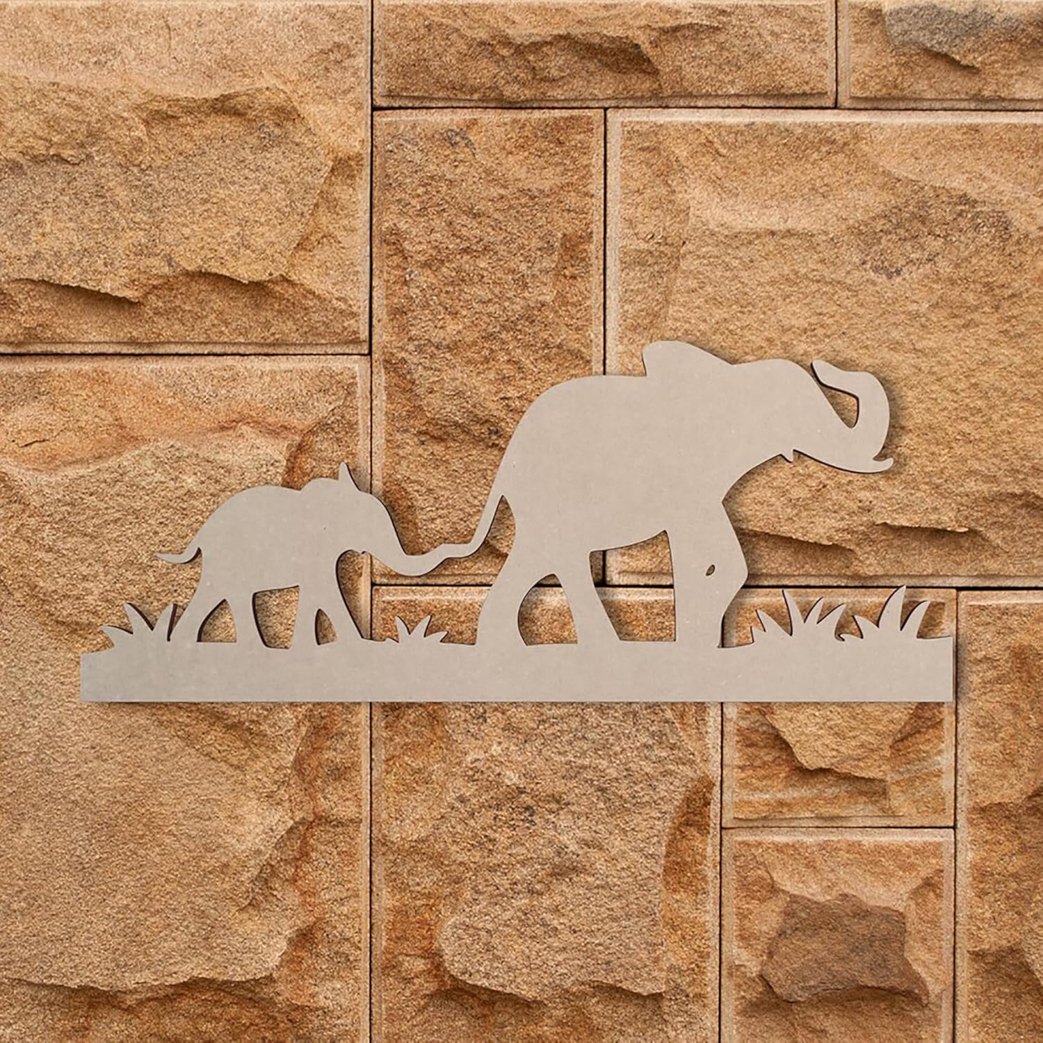 Decorative metal wall art of two elephants on a stone-textured wall.