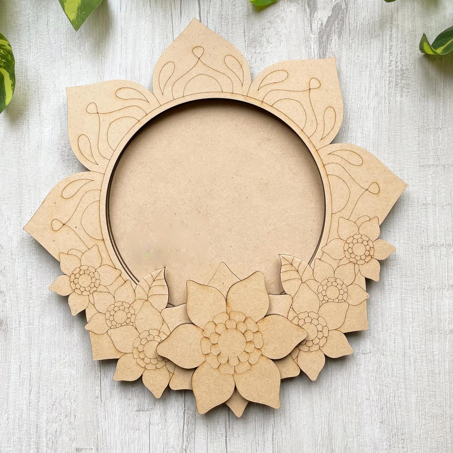 Decorative cardboard wreath with floral patterns on a light wooden surface.