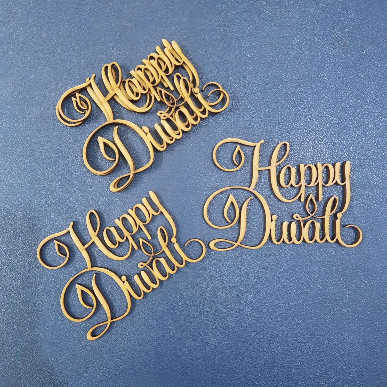 Three decorative wooden signs with 'Happy Diwali' text on a blue background