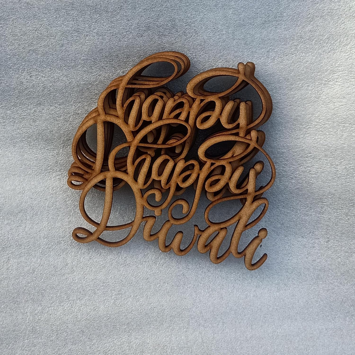 Wooden 'Happy Diwali' decorations on a light gray background