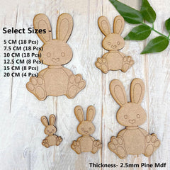 Wooden bunny cutouts of various sizes on a wooden surface with leaf decoration.