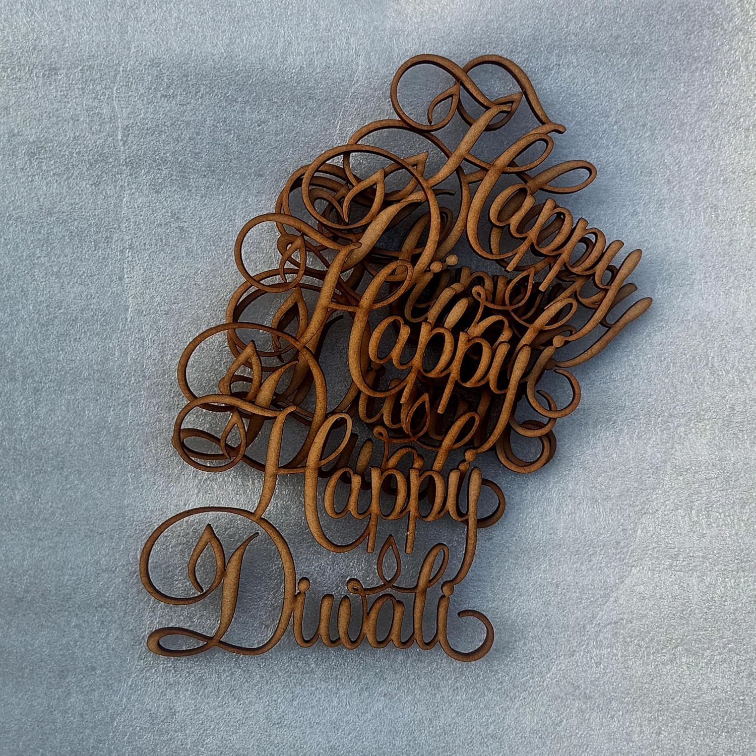 Wooden 'Happy Diwali' decorations on a gray background