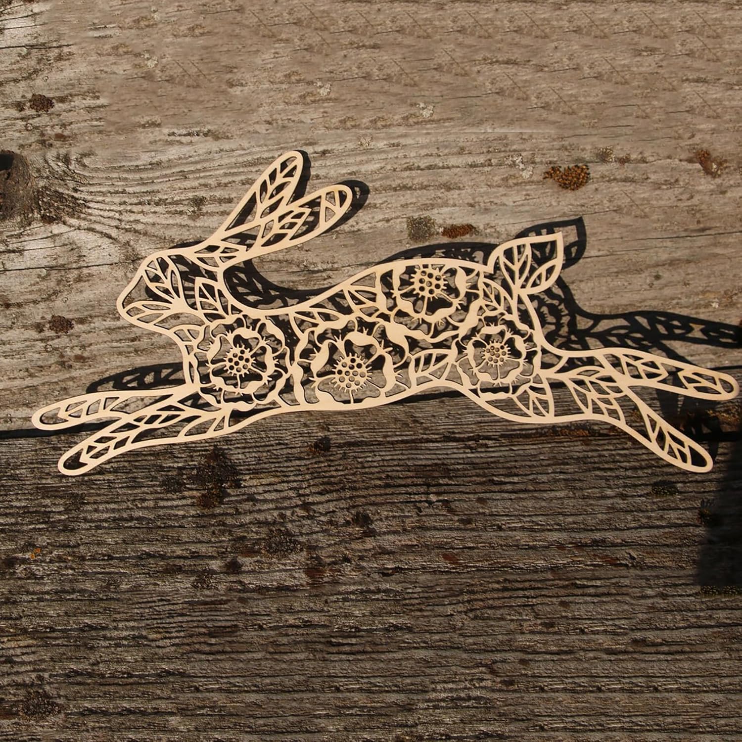 Decorative laser-cut paper rabbit on a wooden surface