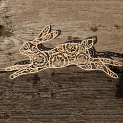 Decorative laser-cut paper rabbit on a wooden surface