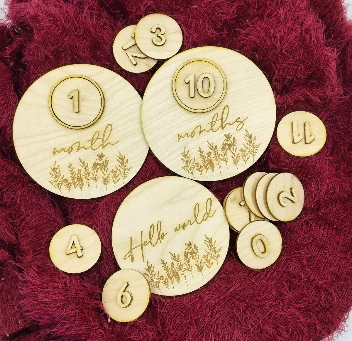 Wooden milestone discs with numbers and text on a red textured background