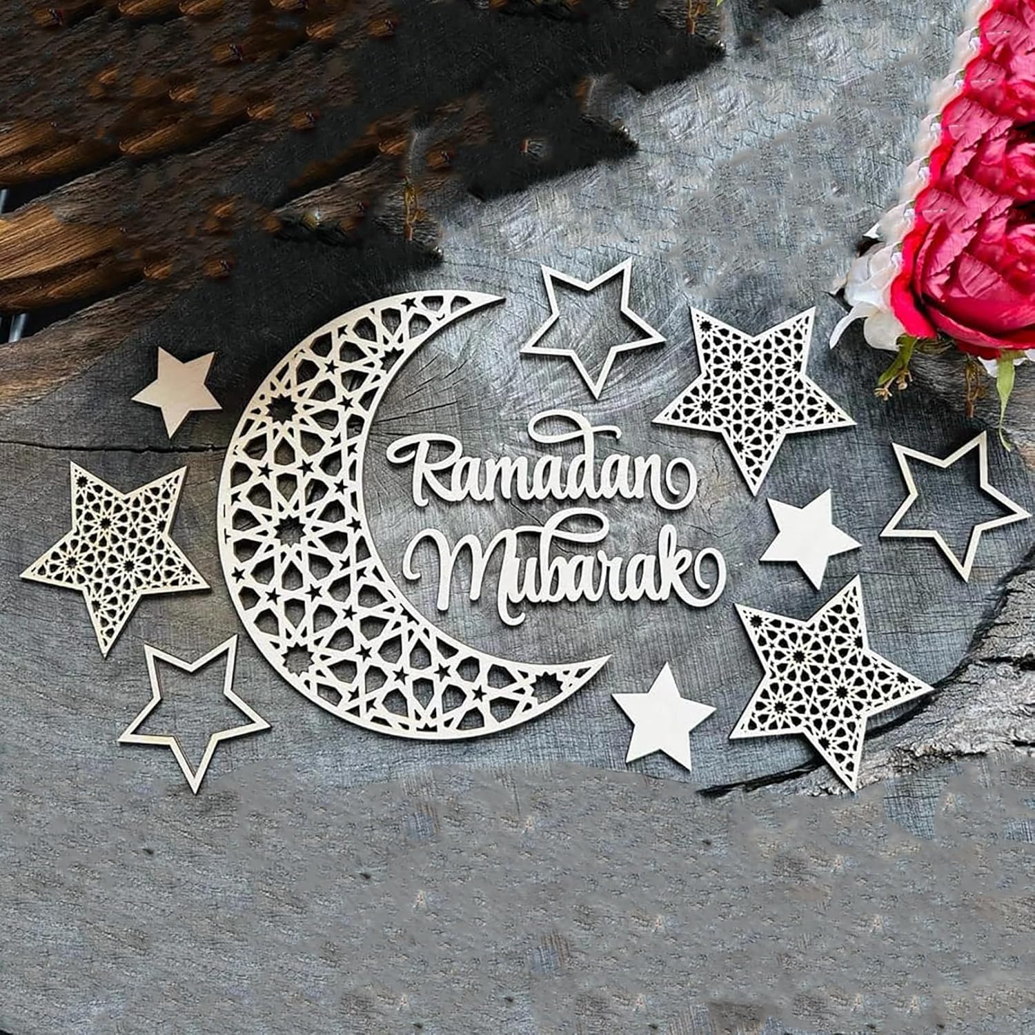 Decorative metal cutout with 'Ramadan Mubarak' text surrounded by stars on a textured surface.