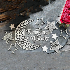Decorative metal cutout with 'Ramadan Mubarak' text surrounded by stars on a textured surface.