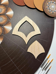 Wooden decorative cutout on a textured surface with color swatches and paintbrushes.
