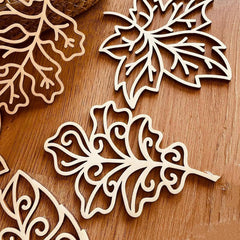 Wooden leaf-shaped cutouts on a wooden surface