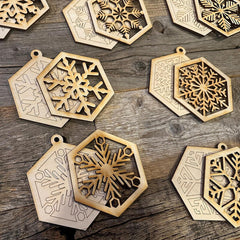 Hexagonal wooden ornaments with snowflake designs on a wooden surface